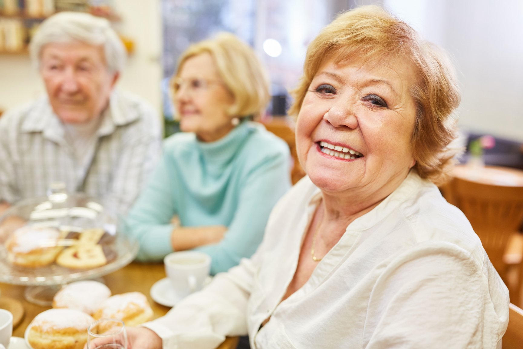 Happy Senior Woman Eating Cake with Friends